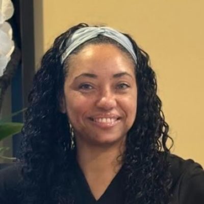 Chiropractic Louisville KY Tatisha Meet the Team Tatisha headshot smiling and wearing a black top.